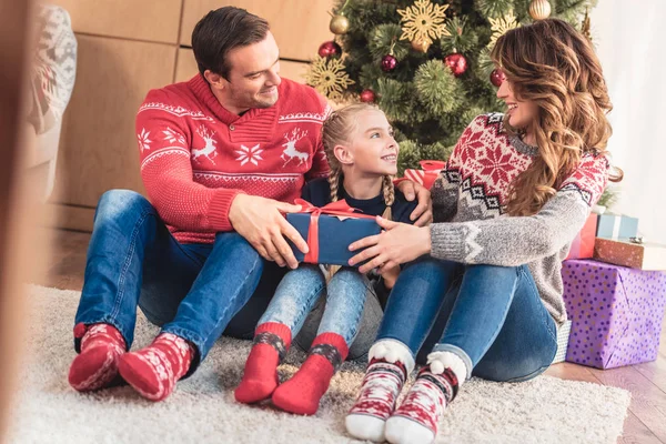 Padres regalando regalo de Navidad a la hija en casa - foto de stock