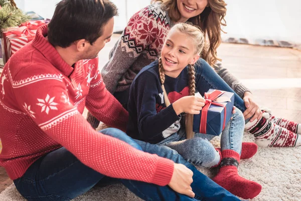 Tochter öffnet Weihnachtsgeschenk und schaut Vater zu Hause an — Stockfoto