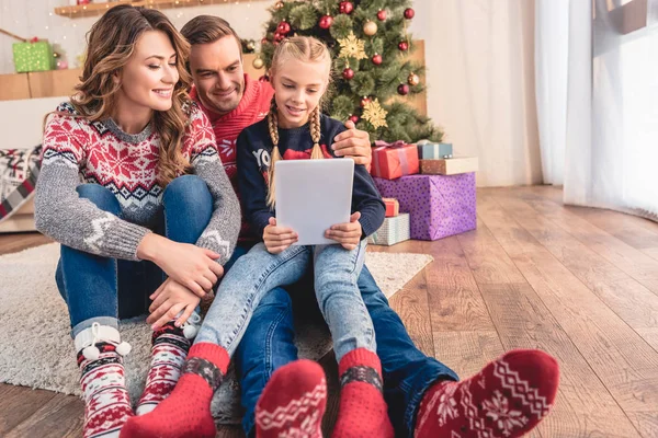 Mutter, Vater und Tochter nutzen gemeinsam Tablet in der Nähe des Weihnachtsbaums zu Hause — Stockfoto