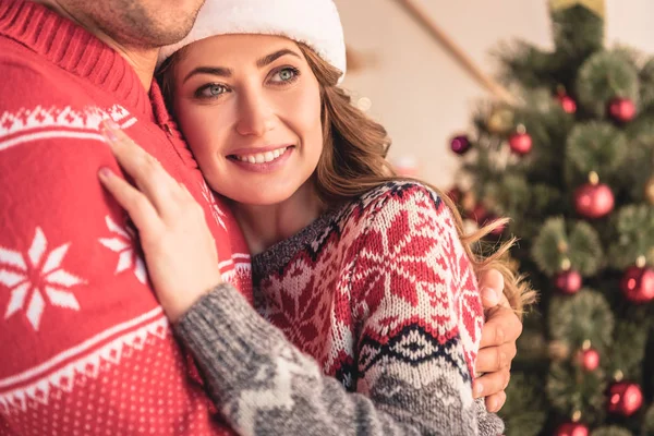 Abgeschnittenes Bild von Mann und lächelnder Frau, die sich am Weihnachtsbaum zu Hause umarmen — Stockfoto