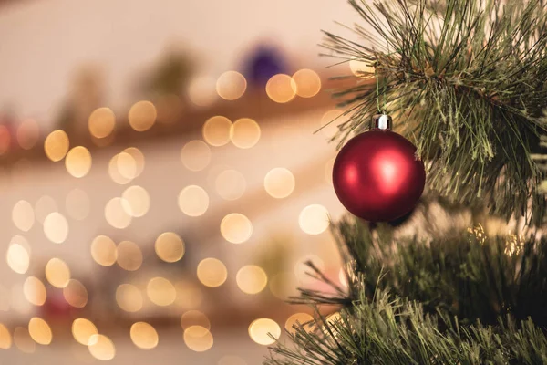 Imagen recortada de árbol de Navidad con juguete rojo en la habitación - foto de stock