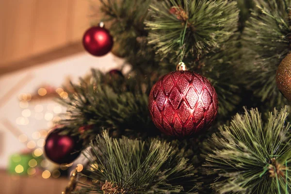 Fuoco selettivo di albero di Natale con bagattelle rosse in camera — Foto stock