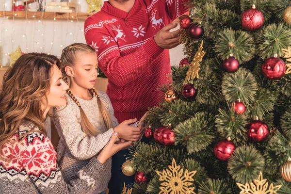 Familie mit Tochter schmückt Weihnachtsbaum zu Hause mit Kugeln — Stockfoto