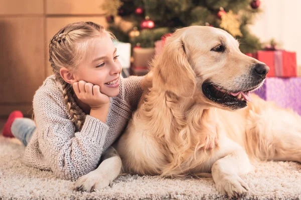 Sorrir jovem e cão engraçado deitado perto da árvore de natal em casa — Fotografia de Stock