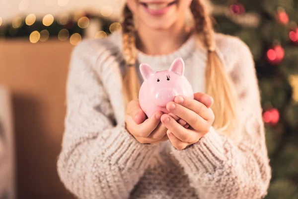 Cropped view of female youngster holding pink piggy bank — Stock Photo