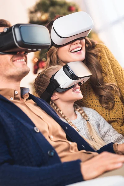 Happy family using virtual reality headsets at home at christmastime — Stock Photo