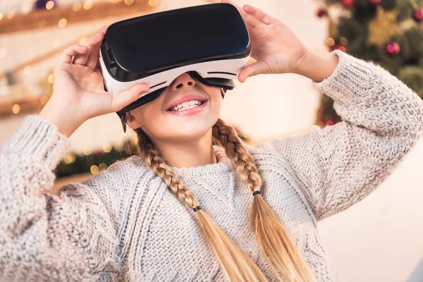 Souriant jeune femme en utilisant vr casque au moment de Noël — Photo de stock