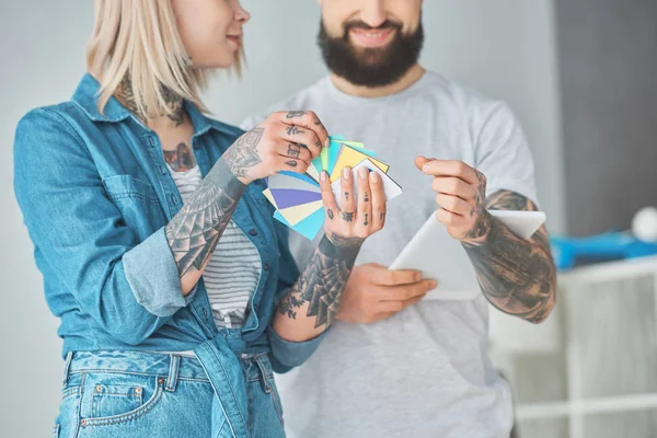 Cropped shot of happy young couple choosing colors for house repair — Stock Photo