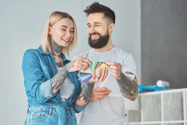 Felice giovane coppia che sceglie i colori per la riparazione della casa — Foto stock