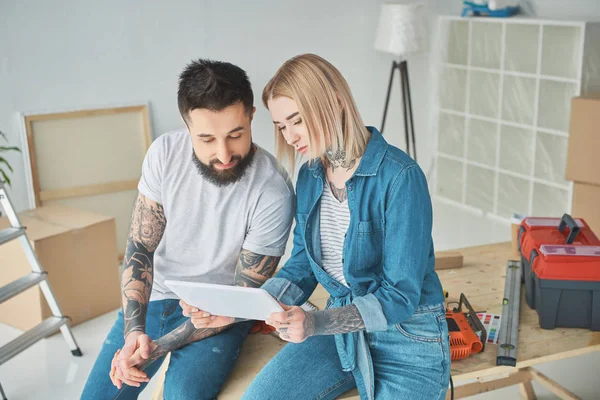 Beautiful young couple using digital tablet during home improvement — Stock Photo