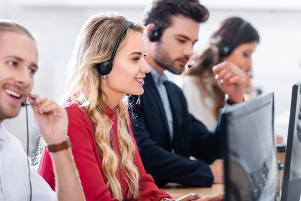 Foco seletivo dos operadores de call center que trabalham no local de trabalho no escritório — Fotografia de Stock