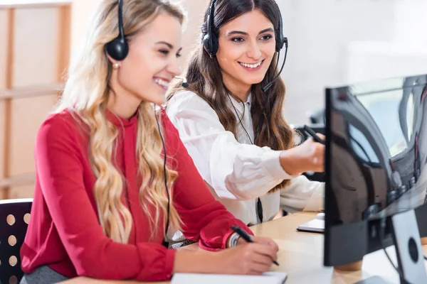 Lächelnde Callcenter-Betreiberinnen am Arbeitsplatz im Büro — Stockfoto