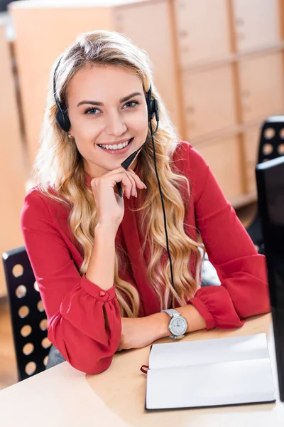 Portrait of smiling female call center operator in headset at workplace in office — Stock Photo