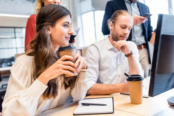 Jeunes collègues d'affaires travaillant sur un projet d'entreprise ensemble sur le lieu de travail avec écran d'ordinateur dans le bureau — Photo de stock