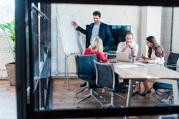 Geschäftsmann zeigt bei Treffen im Amt auf weiße Tafel — Stockfoto