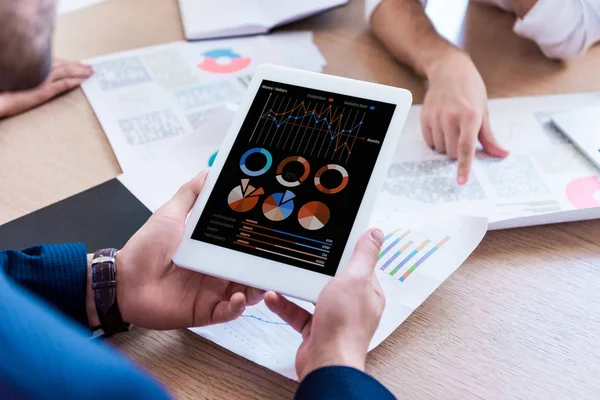 Partial view of businessman holding tablet during meeting in office — Stock Photo