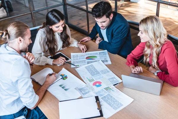 Business team discussing new business project at workplace with papers and laptop in office — Stock Photo