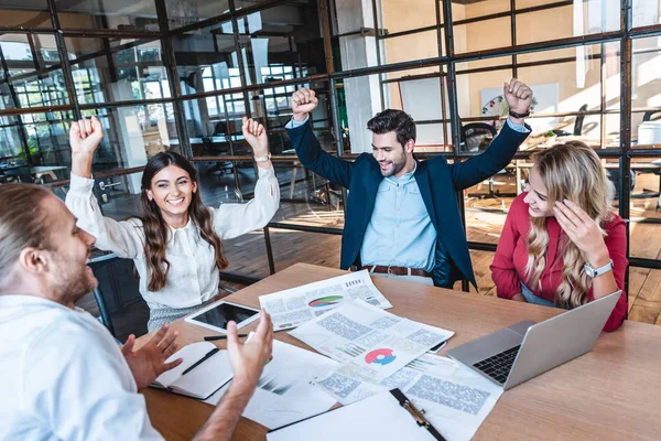 Glückliches erfolgreiches Geschäftsteam am Arbeitsplatz mit Papieren im Büro — Stockfoto