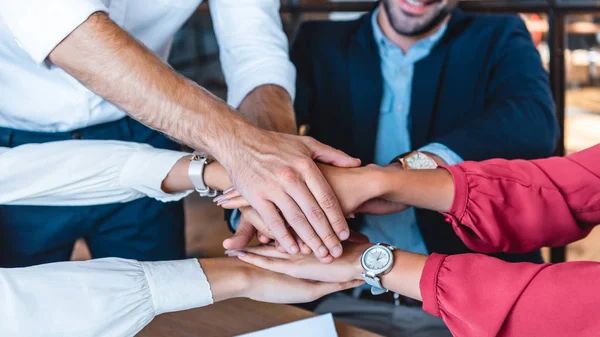 Recortado disparo fo equipo de negocios de la mano en el lugar de trabajo en la oficina - foto de stock