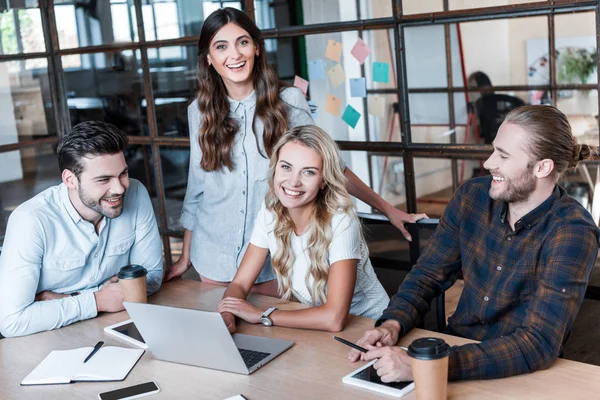 Happy young business colleagues working together and smiling at camera in office — Stock Photo