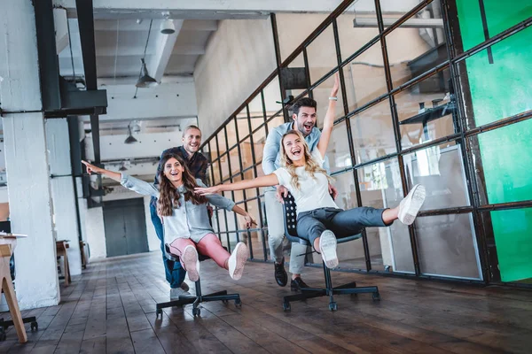 Cheerful young colleagues having fun together at workspace — Stock Photo