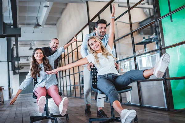 Fröhliche junge Mitarbeiter, die gemeinsam Spaß am Arbeitsplatz haben — Stockfoto