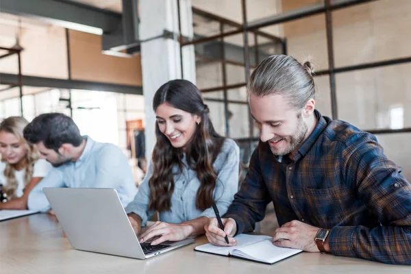 Smiling young business colleagues working together in office — Stock Photo