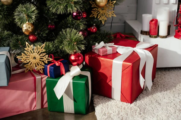 Coffrets cadeaux sous l'arbre de Noël avec des boules dans la chambre — Photo de stock