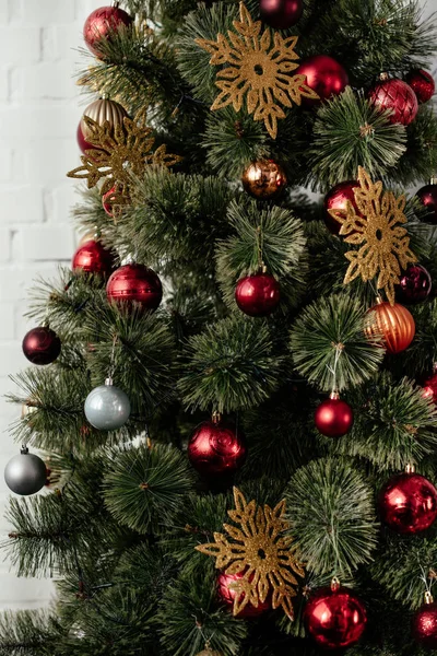 Weihnachtsbaum mit Christbaumkugeln und goldenen Schneeflocken im Zimmer — Stockfoto