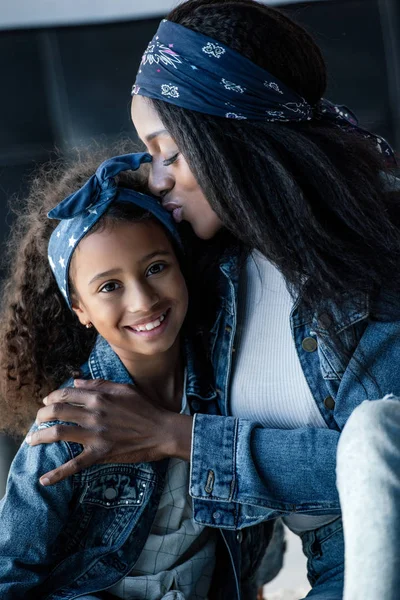 Porträt einer afrikanisch-amerikanischen Mutter, die ihre Tochter zu Hause küsst — Stockfoto