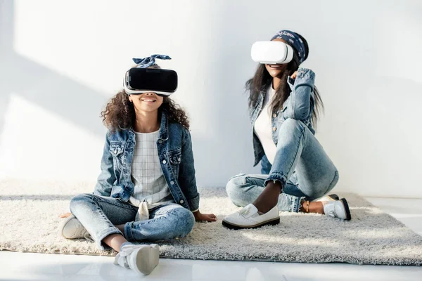 Smiling african american mother and daughter in similar clothing and vr headsets at home — Stock Photo