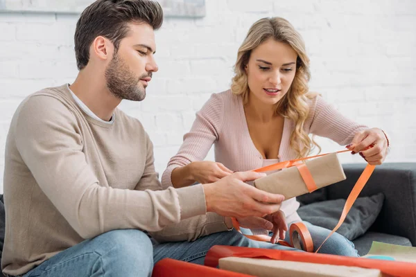 Couple preparing christmas present together at home — Stock Photo