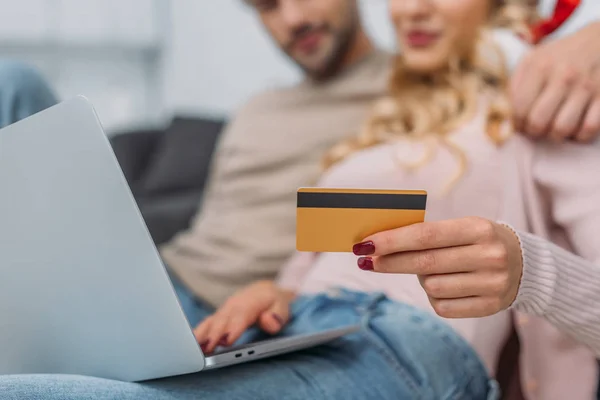 Image recadrée de couple faisant des achats en ligne avec carte de crédit et ordinateur portable à la maison — Photo de stock