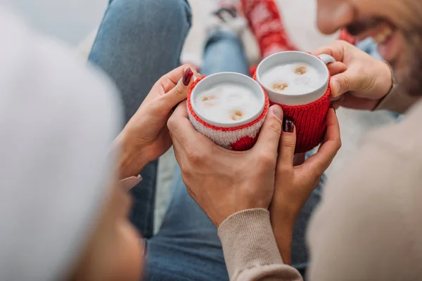 Immagine ritagliata di coppia cliccando con tazze di cappuccino a casa, concetto di Natale — Foto stock