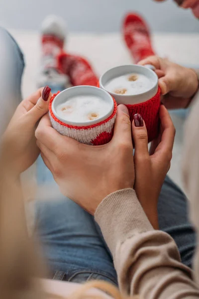 Immagine ritagliata di coppia in possesso di tazze di cappuccino a casa, concetto di Natale — Foto stock