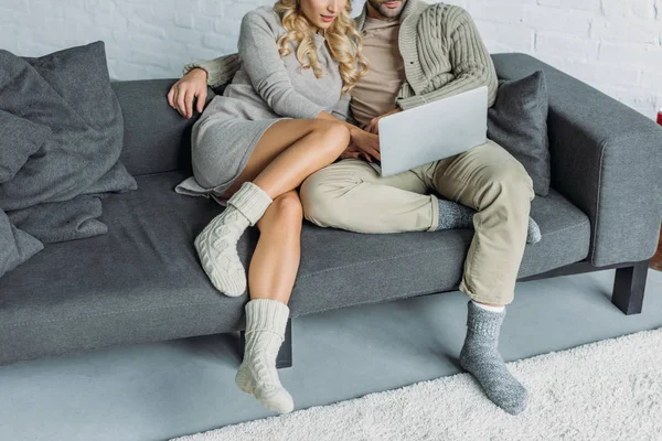 Imagem cortada de casal assistindo algo no laptop no sofá na sala de estar — Fotografia de Stock