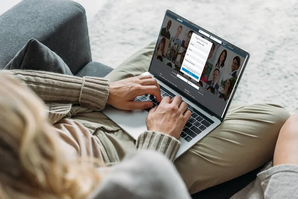 Abgeschnittene Aufnahme eines Paares mit Laptop und linkedin Webseite auf dem Bildschirm auf der heimischen Couch — Stockfoto