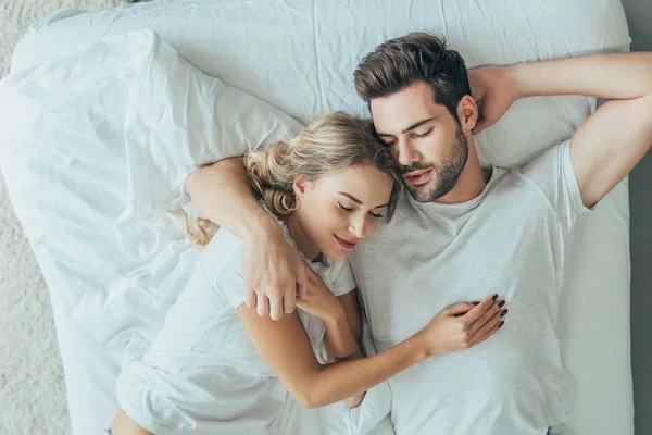 Vue du dessus de beau jeune couple dormant ensemble dans le lit à la maison — Photo de stock