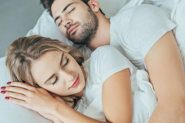 Close-up shot of beautiful young couple sleeping together in bed at home — Stock Photo