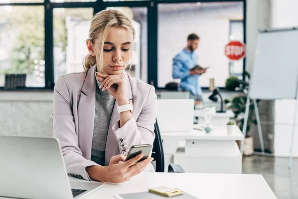 Schöne junge Geschäftsfrau nutzt Smartphone am Arbeitsplatz — Stockfoto