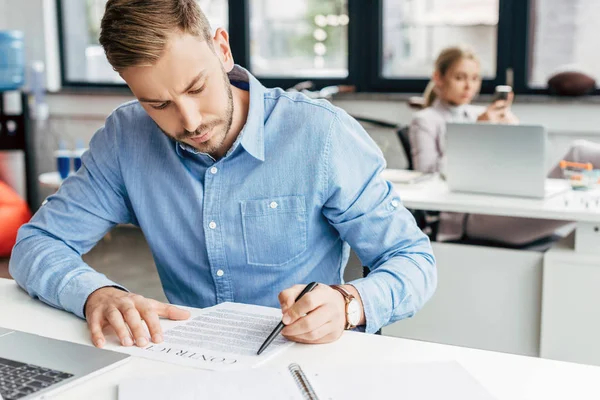 Jovem empresário que trabalha com contrato no escritório — Fotografia de Stock