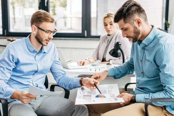 Junges Start-up-Team diskutiert über Geschäftstabellen im Büro — Stockfoto