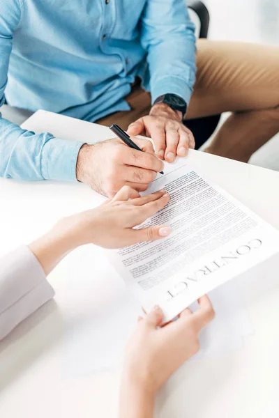 Close-up vue partielle des hommes d'affaires qui signent un contrat en fonction — Photo de stock