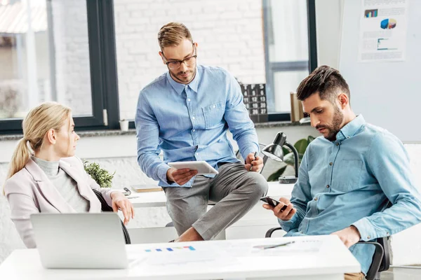 Jeunes collègues d'affaires masculins et féminins travaillant ensemble au bureau — Photo de stock