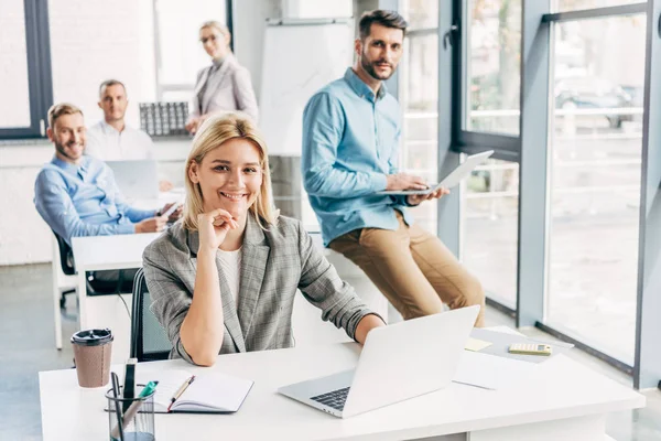 Young start up team smiling at camera while working in office — Stock Photo