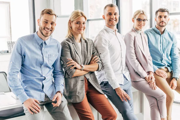 Heureux professionnel jeune start-up équipe souriant à la caméra au bureau — Photo de stock