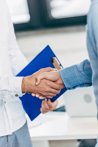Обрезанный снимок коллег, пожимающих руки во время деловой встречи — стоковое фото