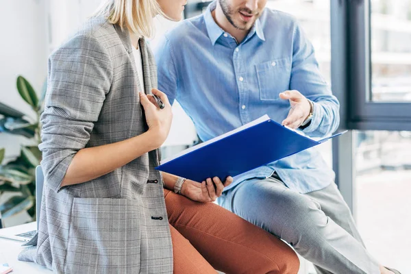 Schnappschuss von jungen Geschäftskollegen, die Ordner in der Hand halten und mit Papieren im Büro arbeiten — Stockfoto