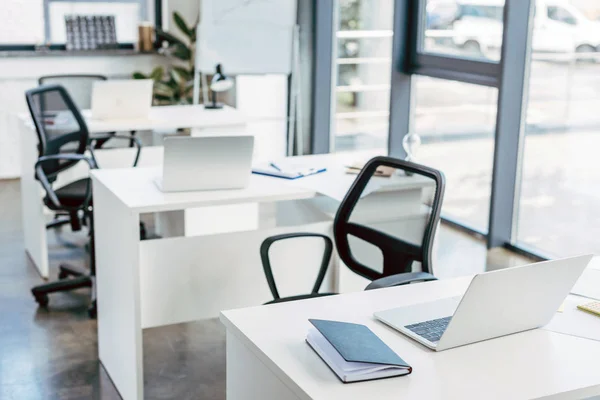 Laptop auf Tischen im leeren modernen Büro — Stockfoto