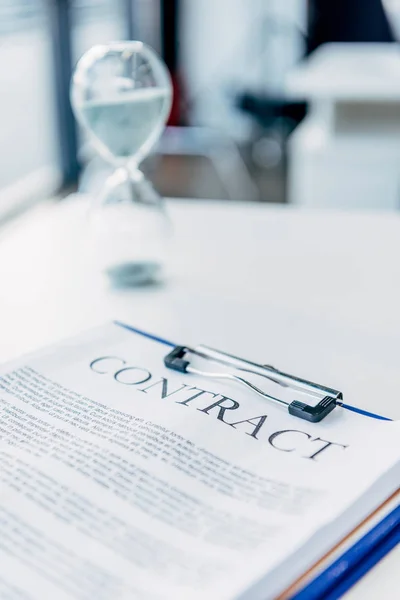 Primer plano del portapapeles con contrato en escritorio blanco en la oficina - foto de stock